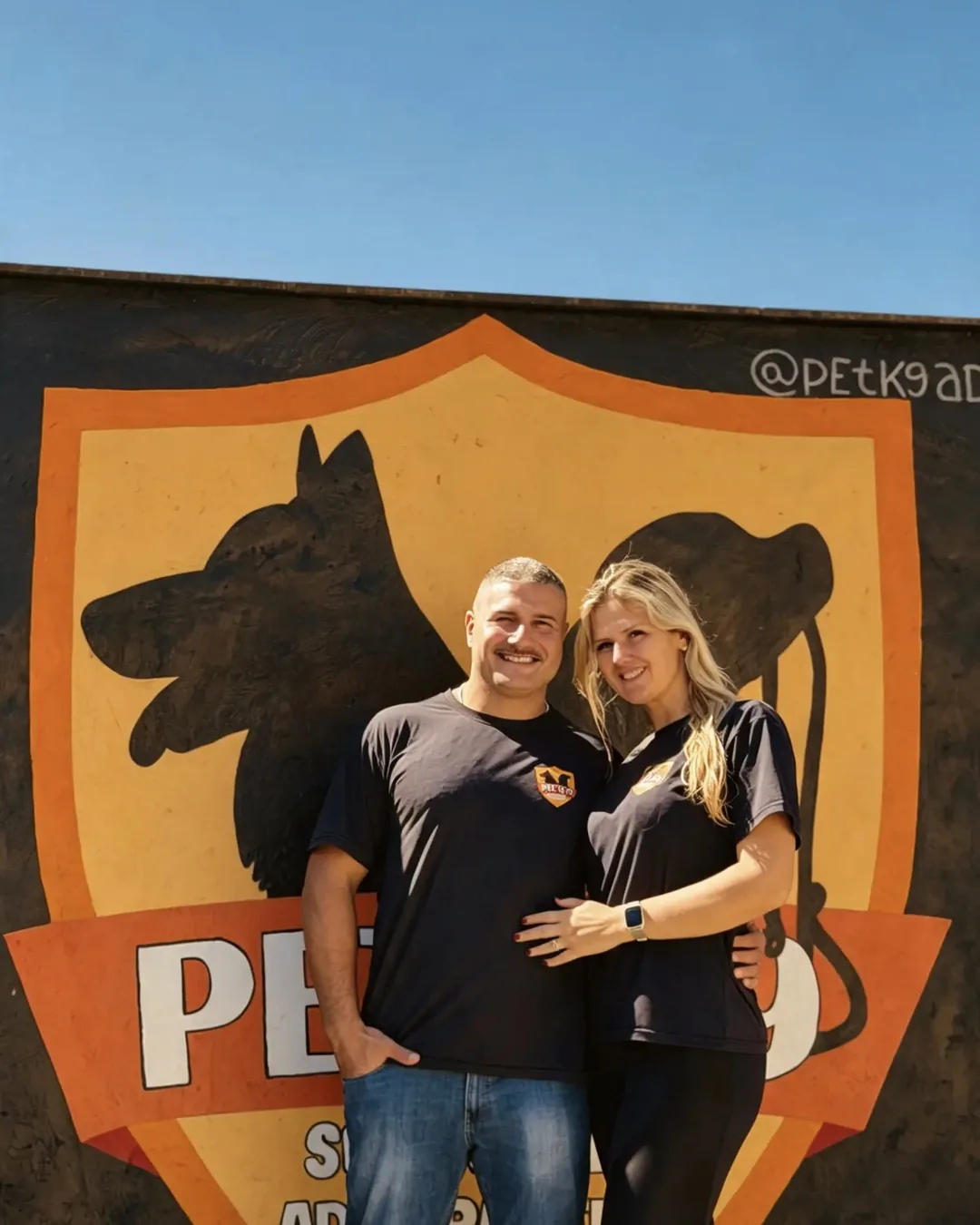 Bruno e Vanessa, da Pet K-9, em frente ao painel da marca